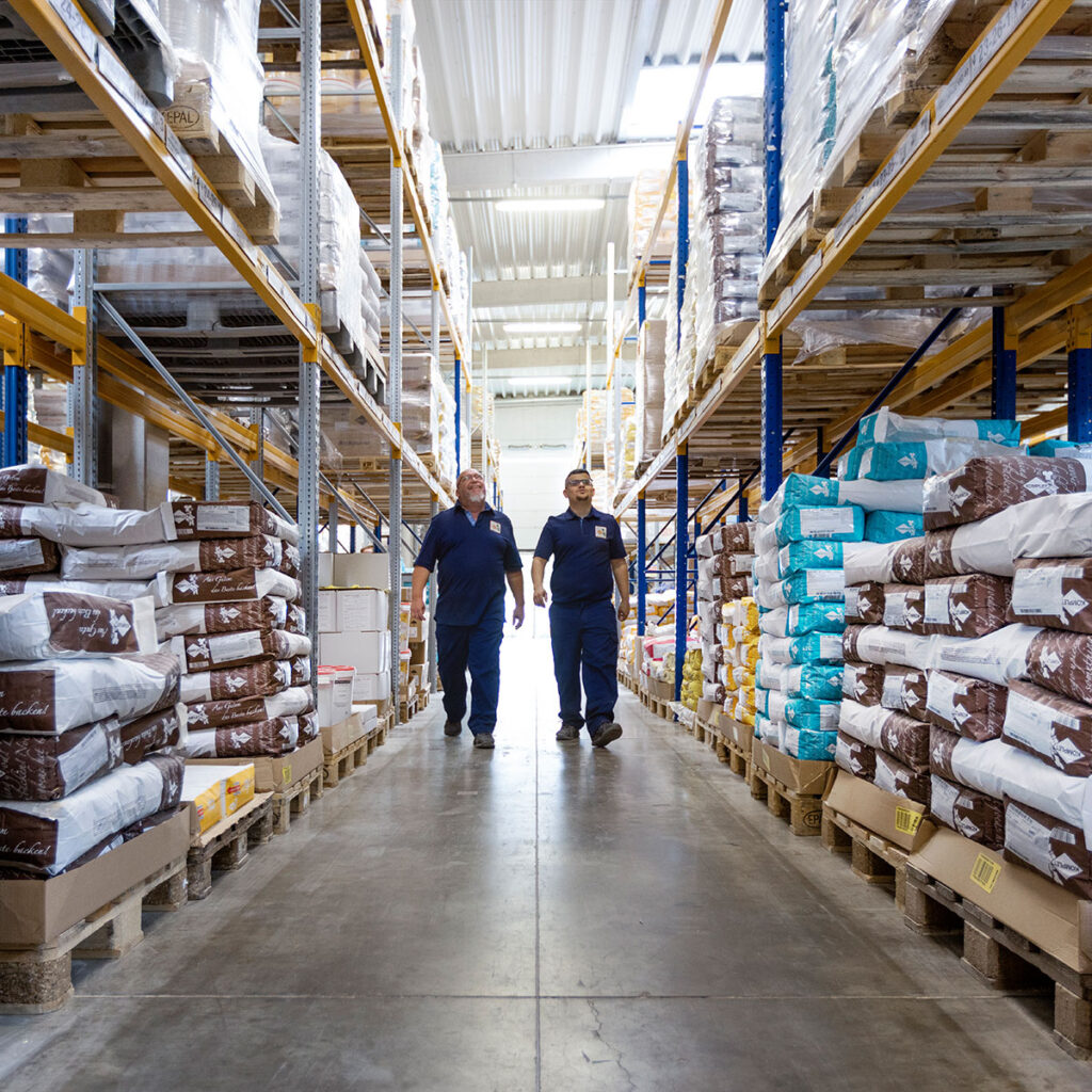 Zwei Mitarbeiter laufen durch das Lager.